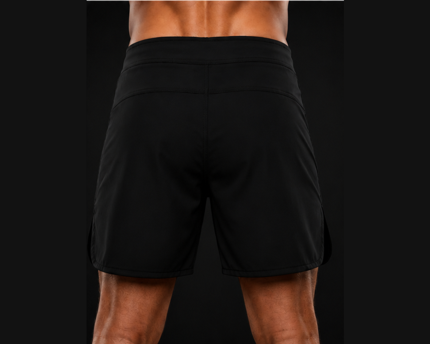 Black athletic shorts worn by a person on a black background